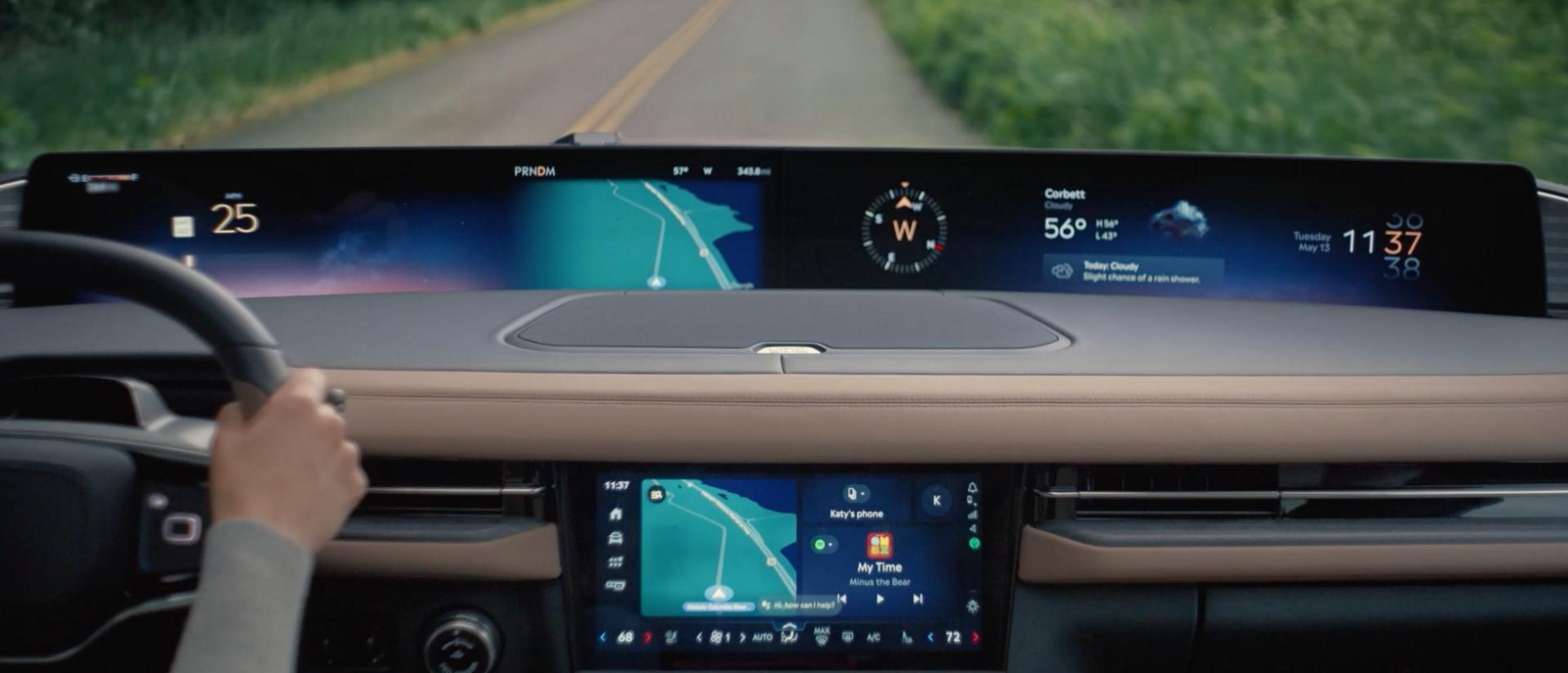 Une photo de conduite intérieure du Lincoln Navigator® 2027 montrant le conducteur utilisant l’Assistant Google à commande vocale