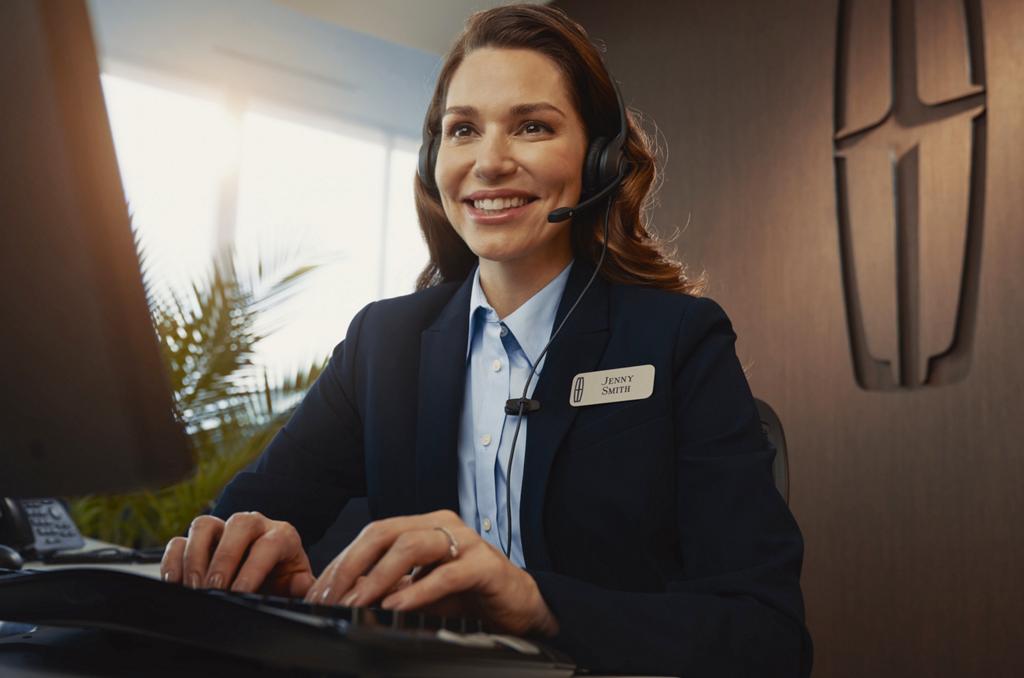 Un personnel de soutien de Lincoln avec un casque d’écoute et souriant.