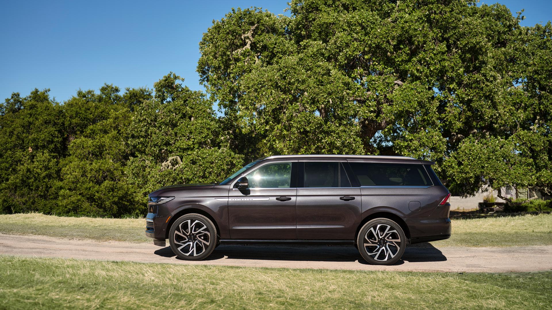 Un Lincoln Navigator® 2026 à empattement long en option est stationné sur une route bordée d’arbres