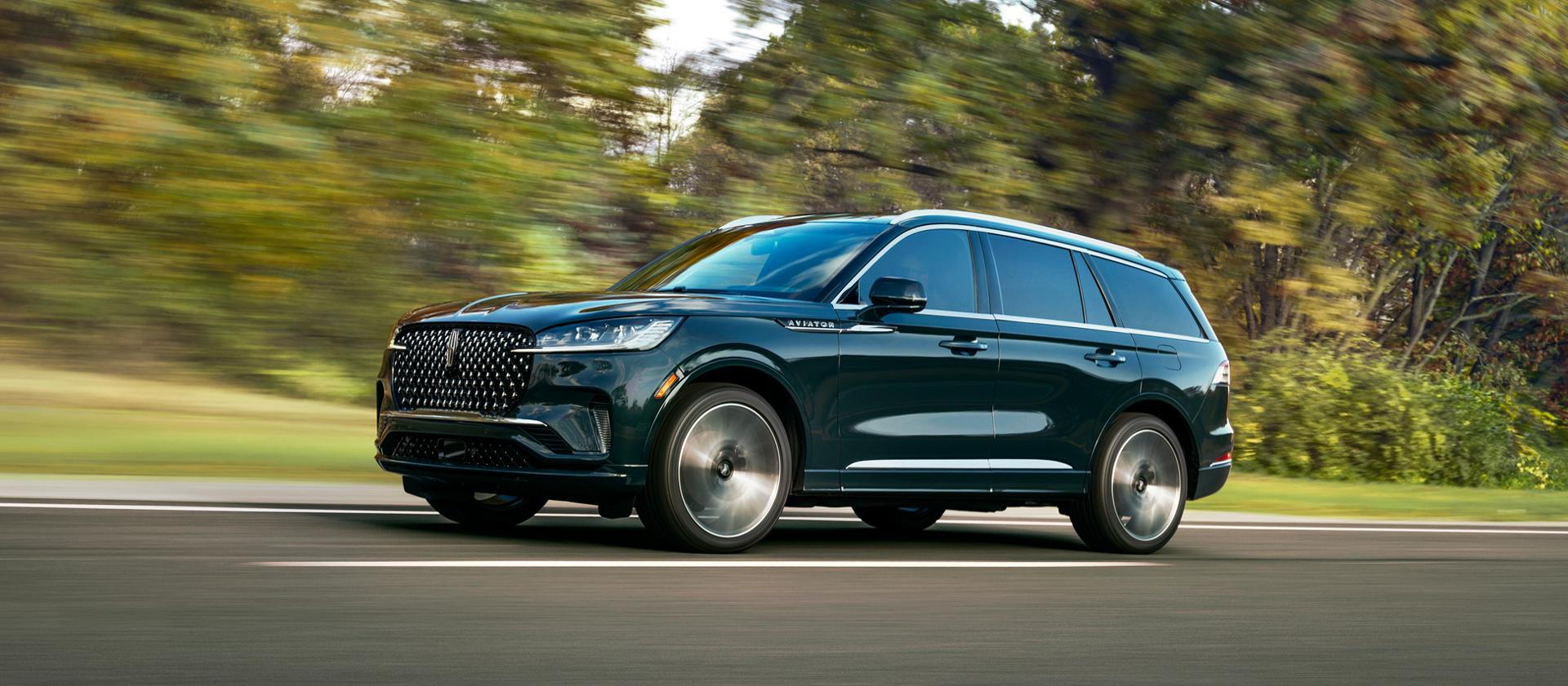 Un Lincoln Aviator® Black Label® 2027 roulant dans une campagne luxuriante