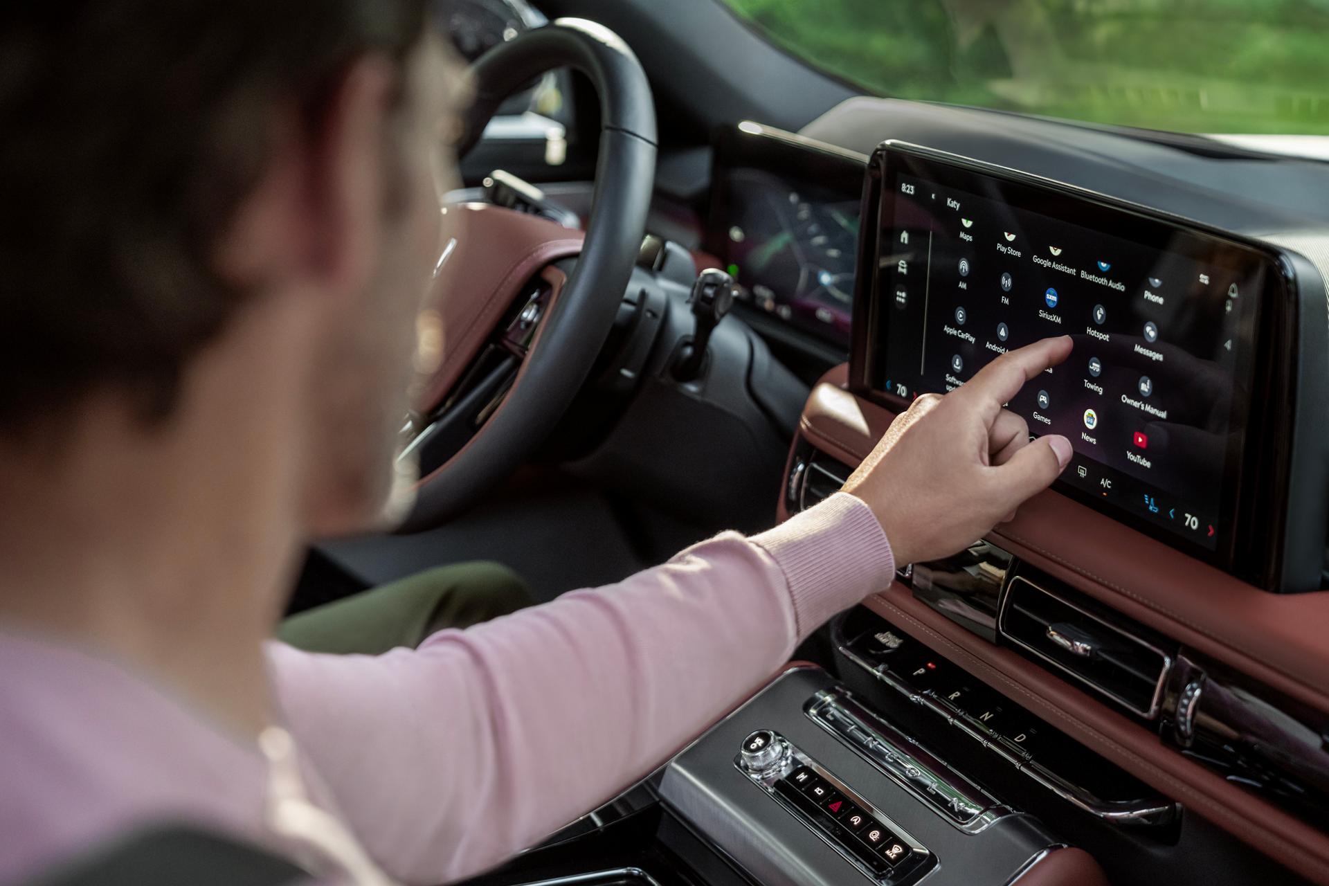 Le passager avant d’un VUS Lincoln Aviator® 2027 interagit avec l’écran central
