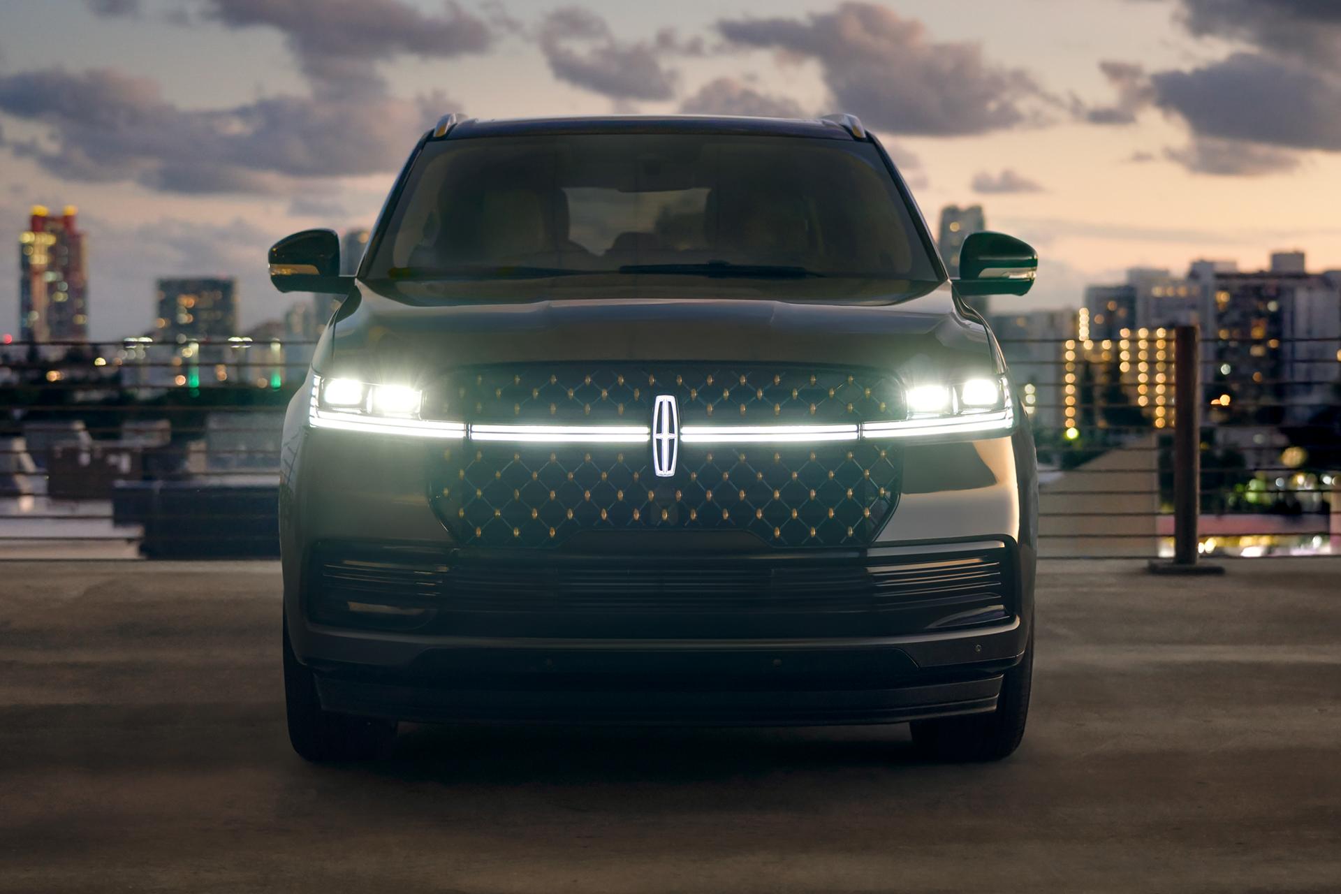 L’avant d’un VUS Lincoln Navigator® 2027 avec les phares et le Lincoln Star illuminés au crépuscule