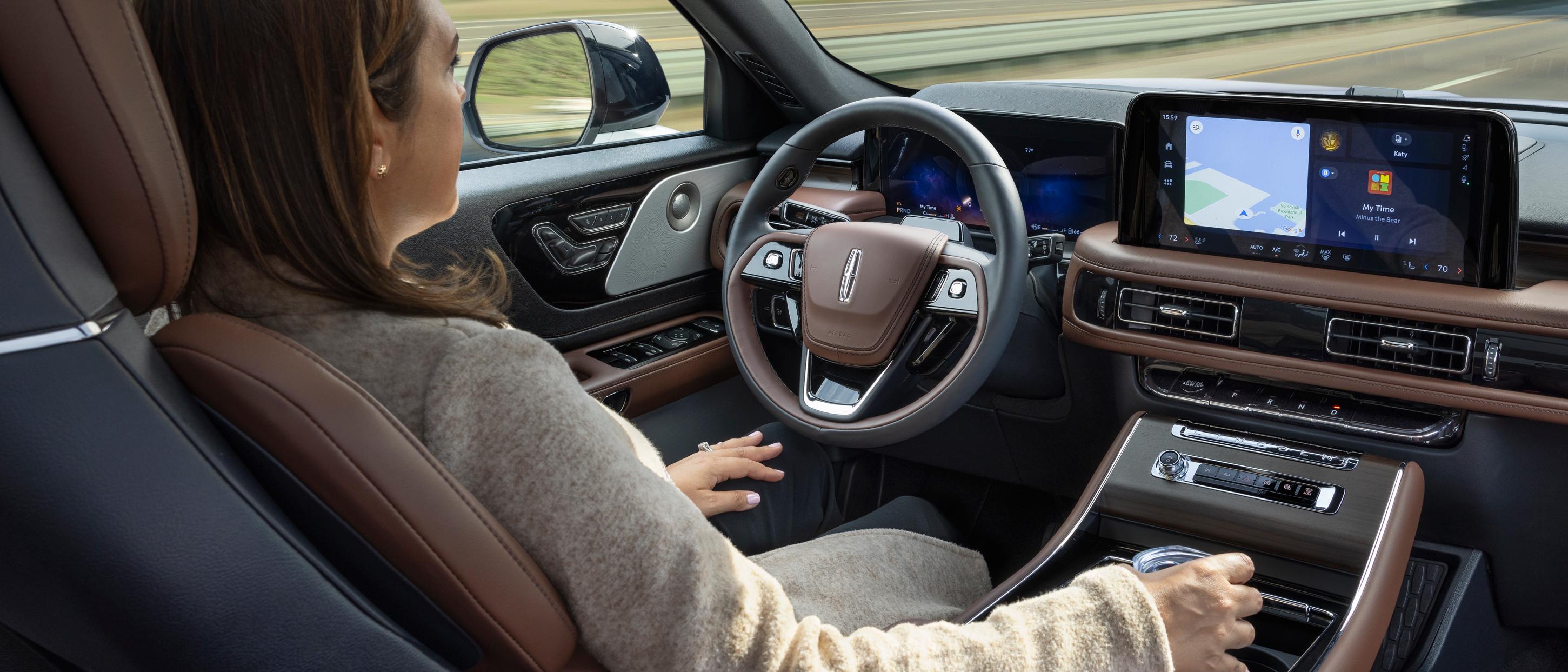 Une femme conduit le VUS Lincoln Aviator® 2026 en mode mains libres avec les yeux sur la route en utilisant le Lincoln BlueCruise