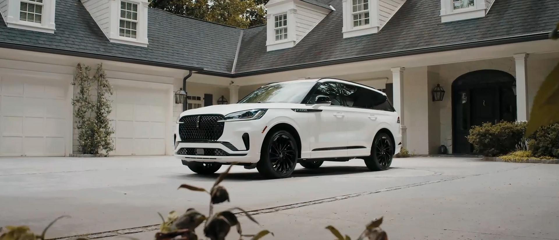 Un Lincoln Aviator® 2026 est stationné dans l’entrée d’une maison luxueuse