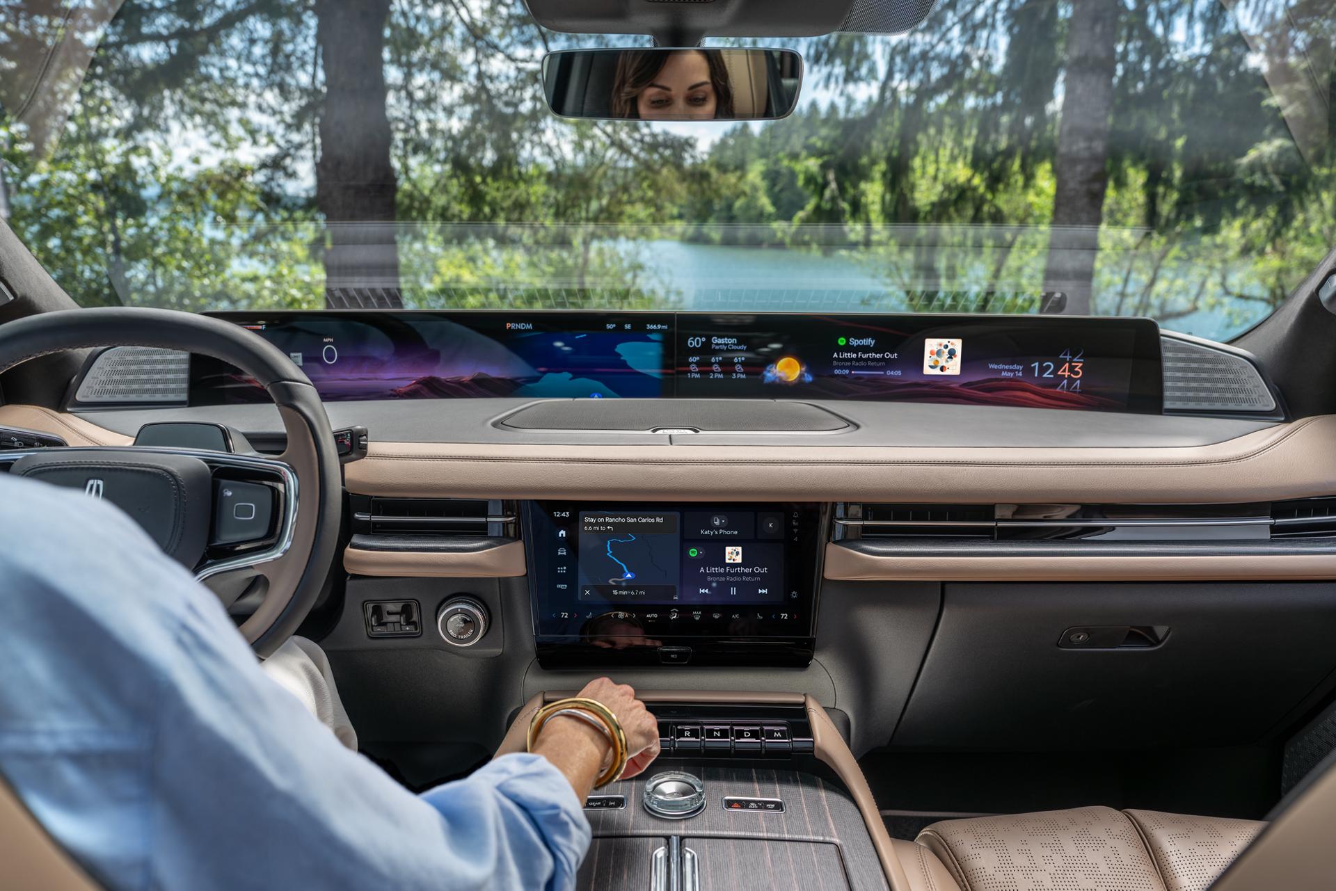 Le conducteur d’un VUS Lincoln Navigator® 2027 tend la main vers le bouton de volume inspiré du cristal