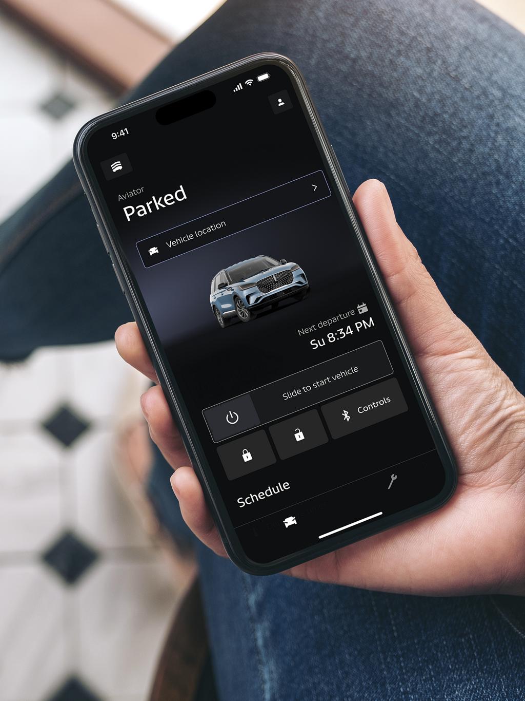 Une personne tenant un téléphone avec l’application Lincoln ouverte à l’écran.