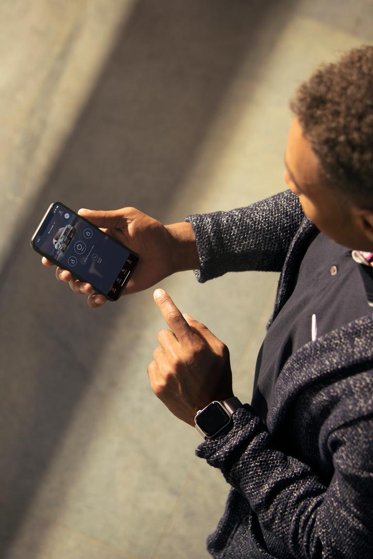 Un homme regarde l’application Lincoln sur son téléphone intelligent, en pointant à l’écran