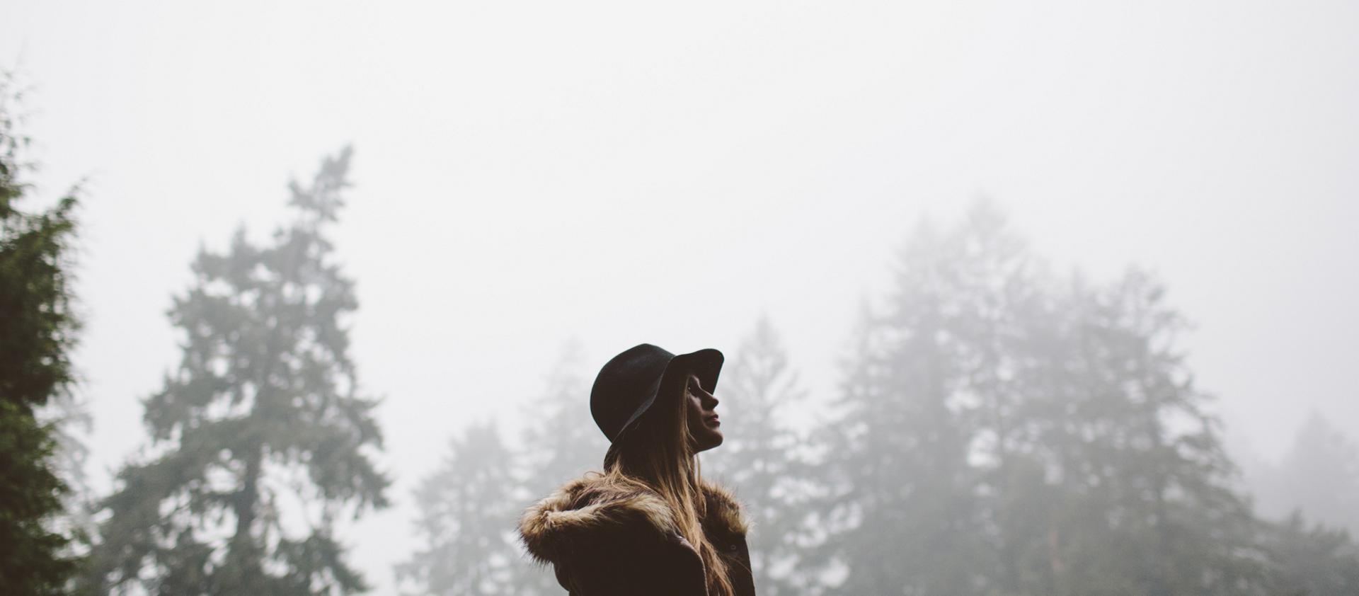 Une femme marche dans la forêt après la fin d’une tempête de pluie