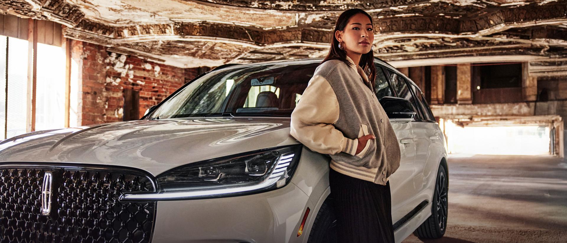 Une femme debout à l’extérieur de son véhicule Lincoln.