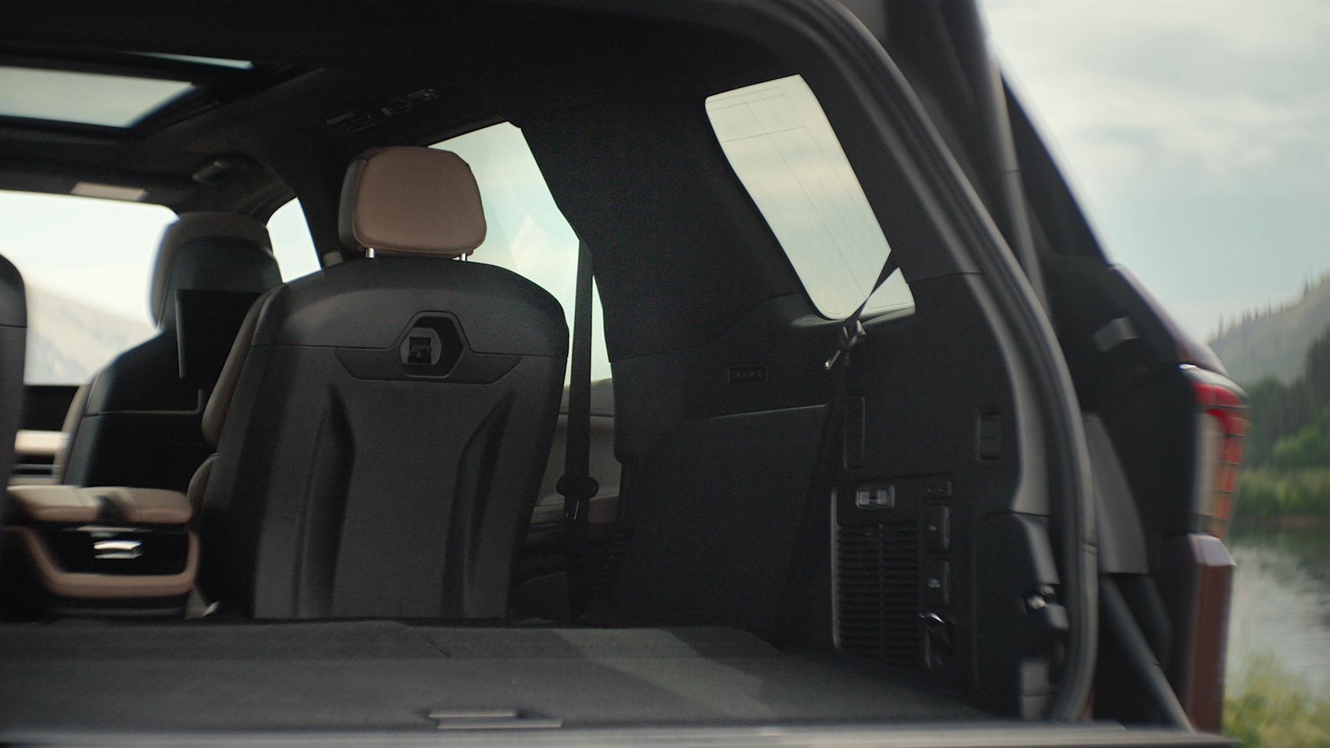 Un VUS Lincoln Navigator® 2027 avec le hayon divisé Lincoln ouvert montrant une troisième rangée rabattue