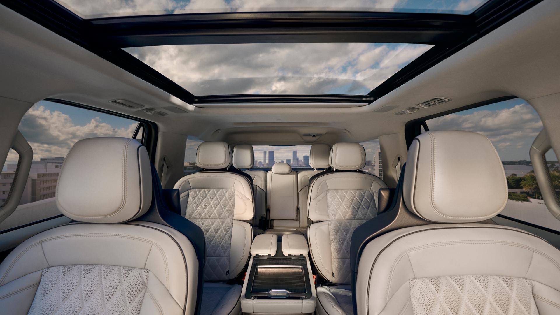 L’intérieur spacieux d’un Lincoln Black Label Navigator® 2026 est montré en regardant à travers l’habitacle, avec le toit panoramique Vista ouvert au-dessus