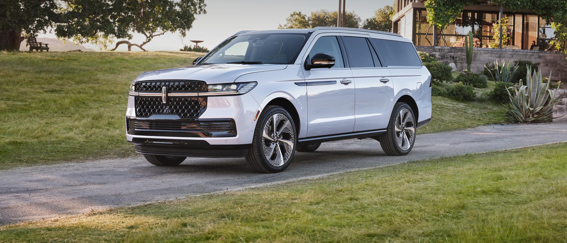 Un SUV Lincoln Navigator de 2026 garé devant une maison moderne.