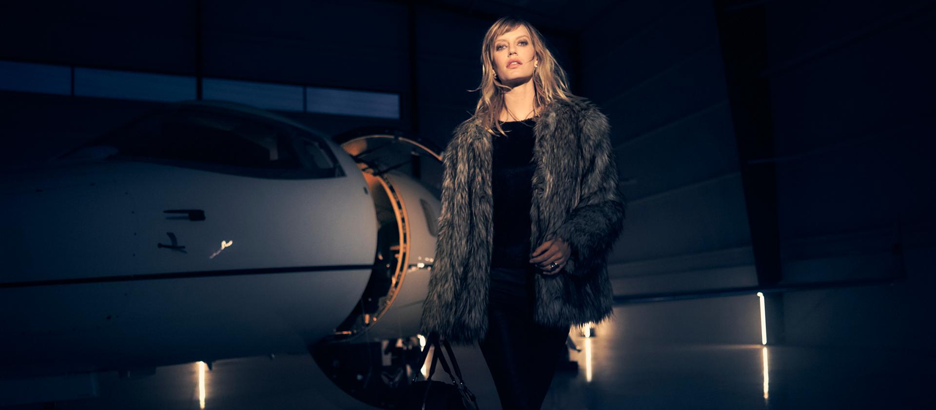 Une femme élégamment vêtue sortant d’un jet privé
