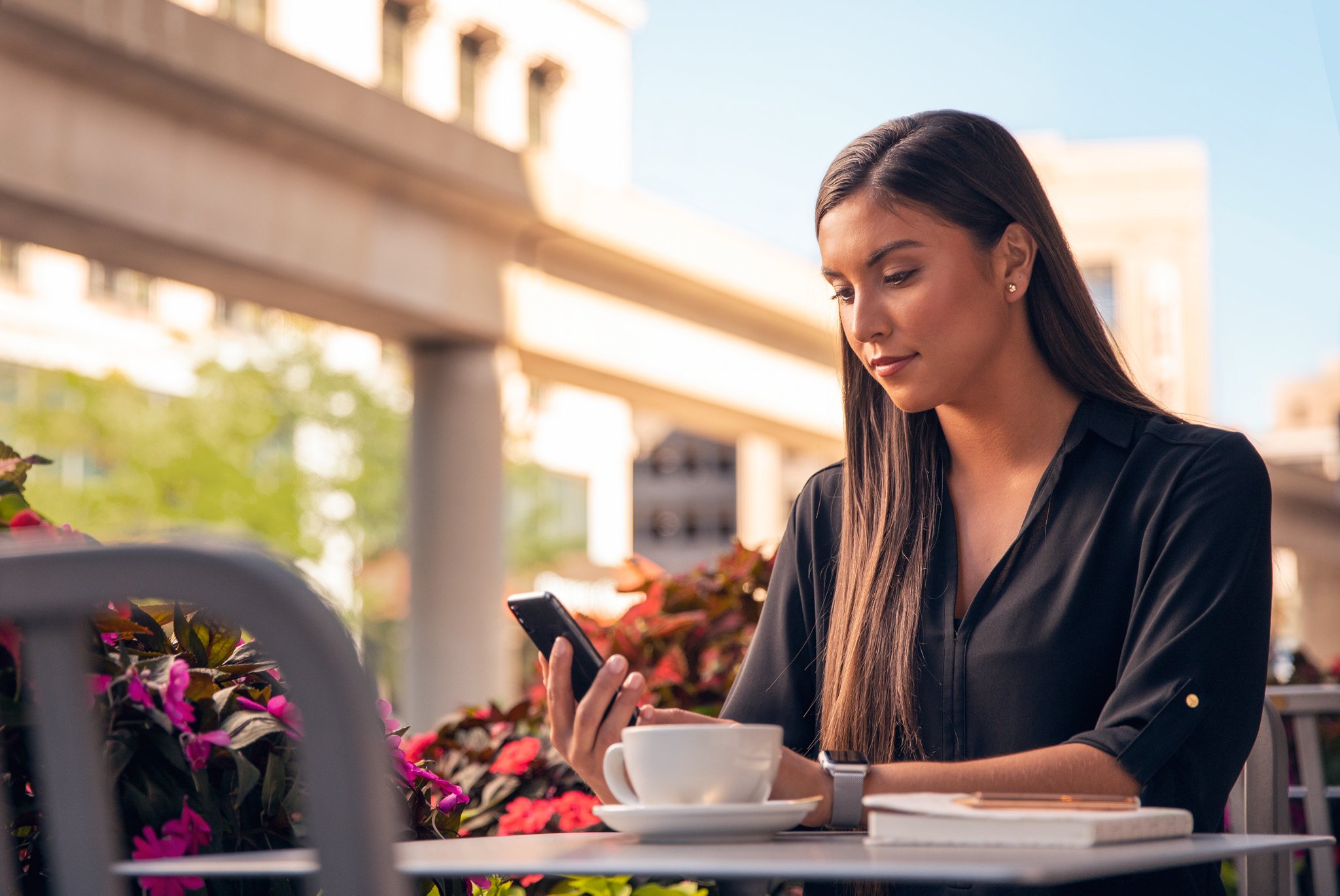 Une femme assise à une table regardant son téléphone.