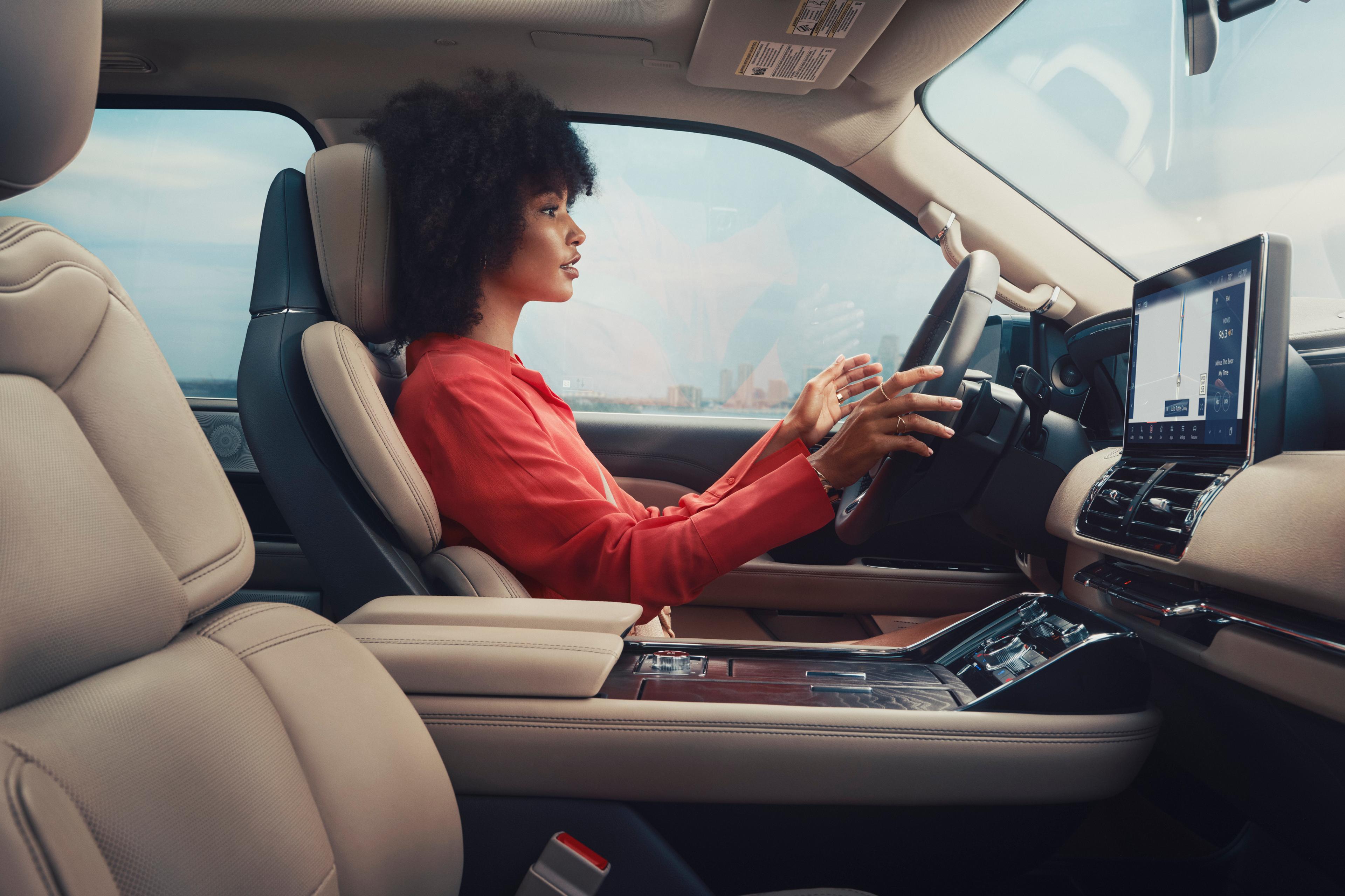 Une femme assise dans un véhicule Lincoln utilisant la technologie BlueCruise.