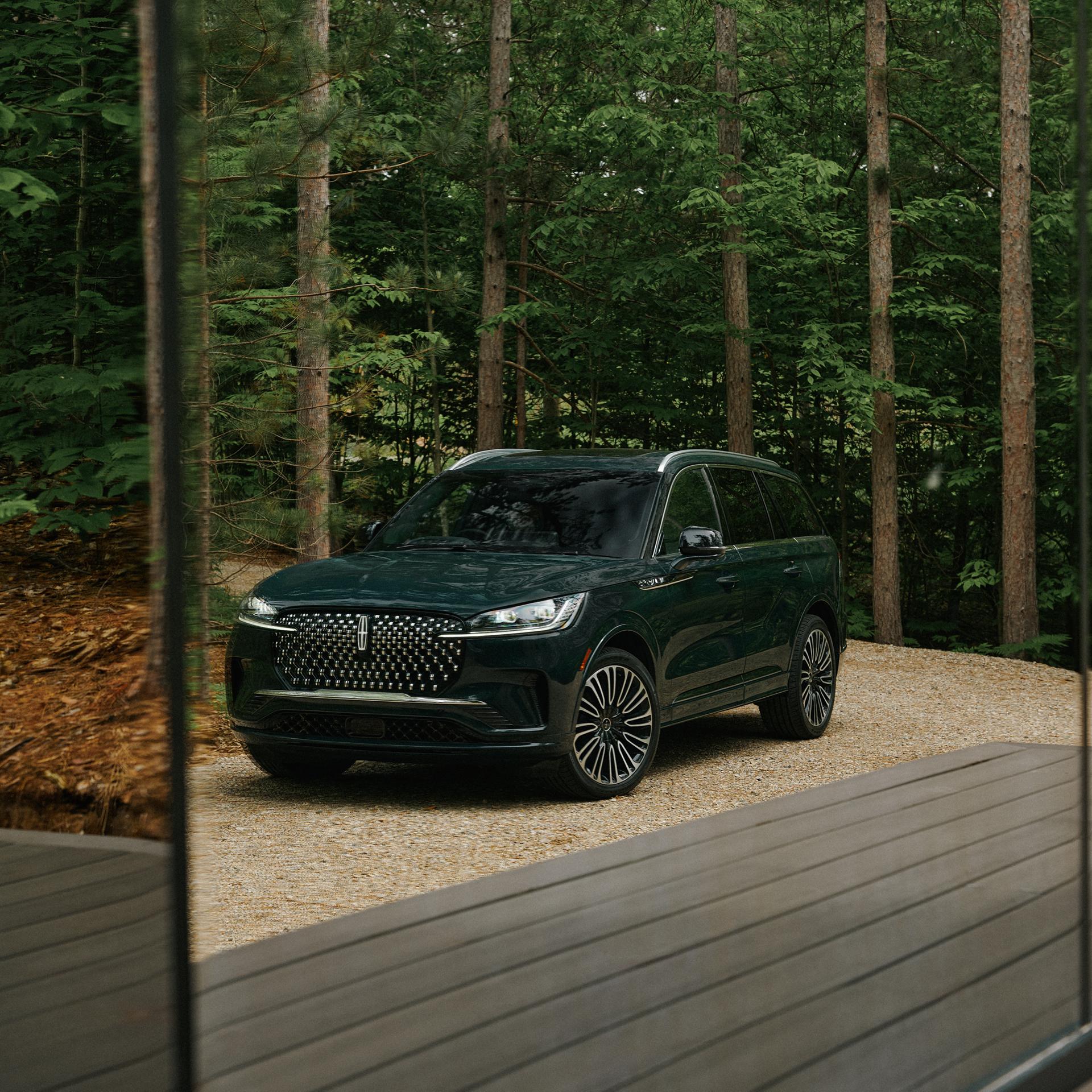 Un Lincoln Aviator® Black Label™ 2027 stationné à côté d’un site de camping haut de gamme
