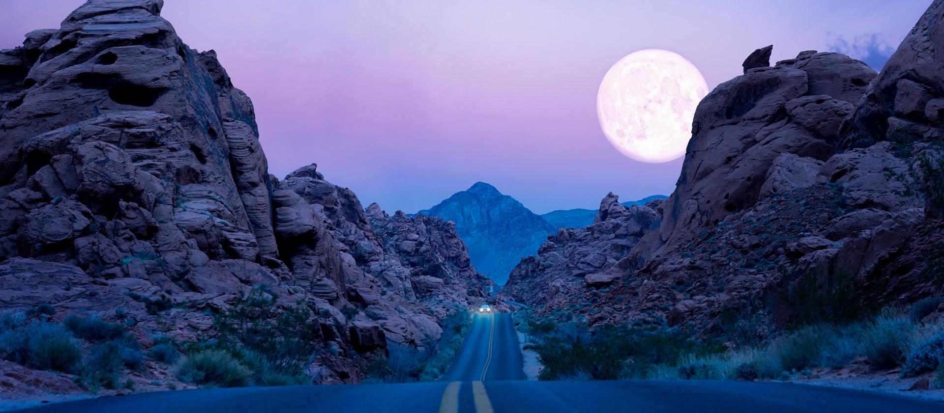 Une lune suspendue au-dessus d'une autoroute dans le désert