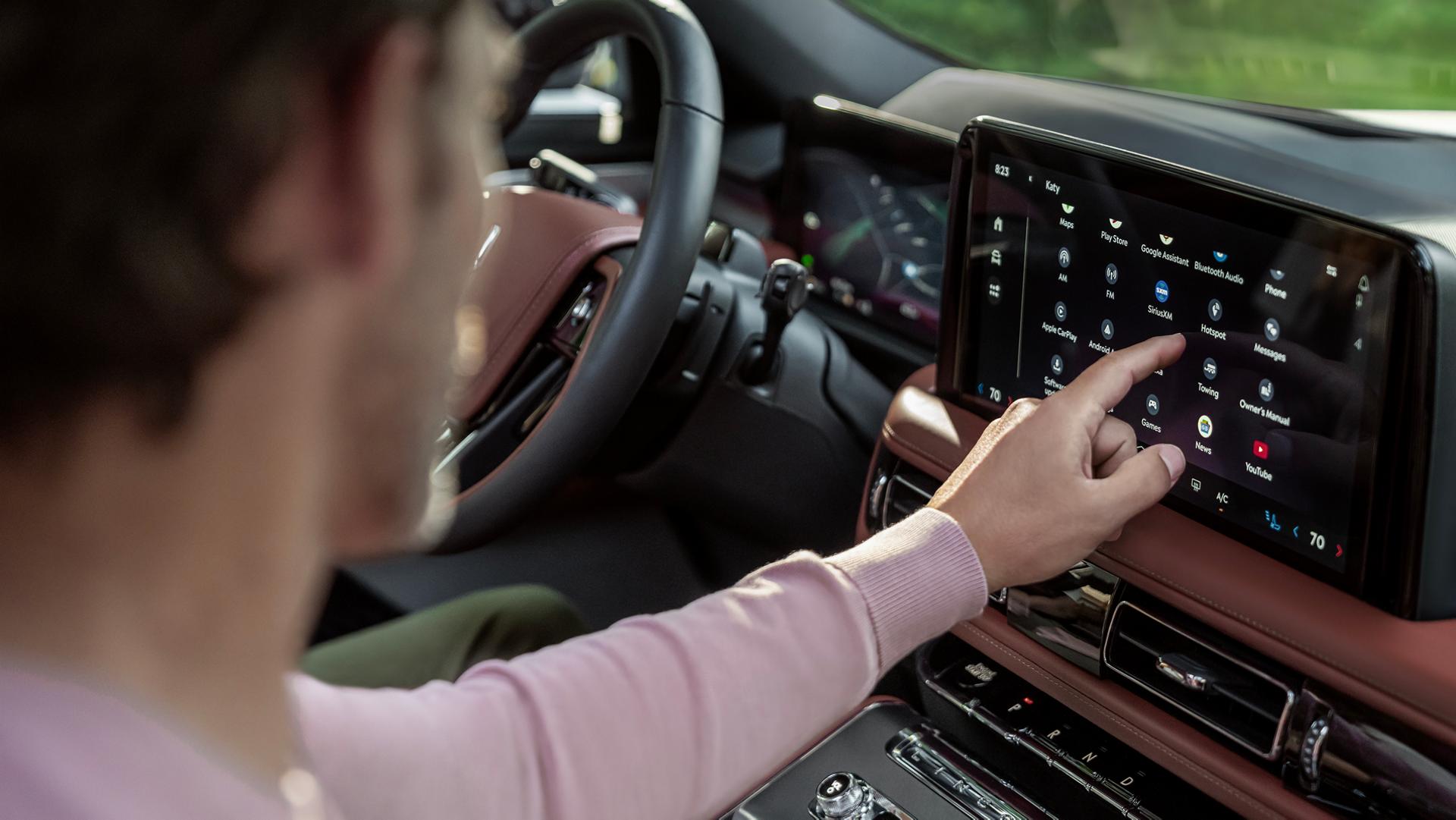Le passager avant touche l’écran tactile central à l’intérieur d’un Lincoln Aviator 2026