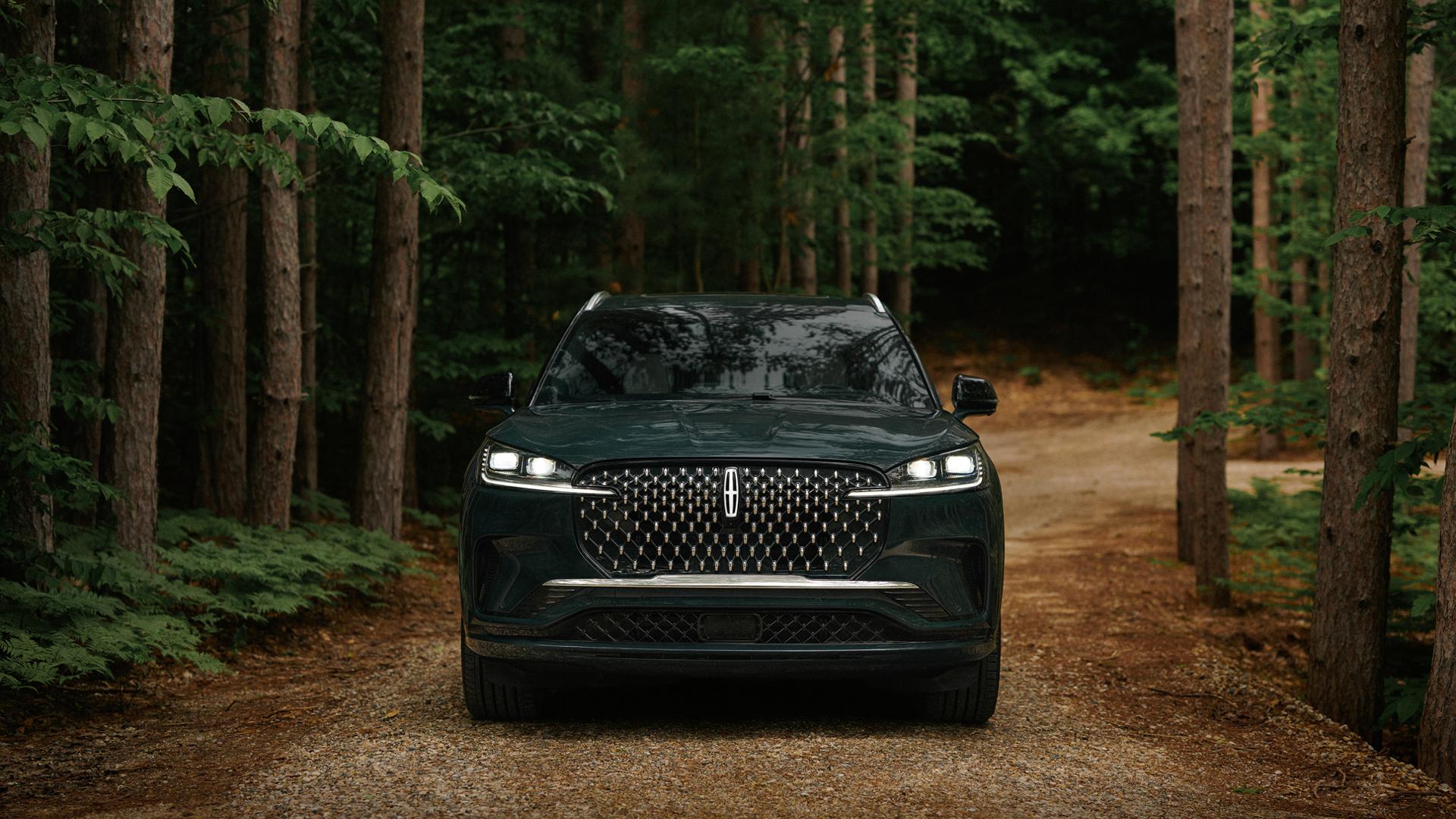 Un Lincoln Aviator® 2027 circulant sur une route forestière isolée