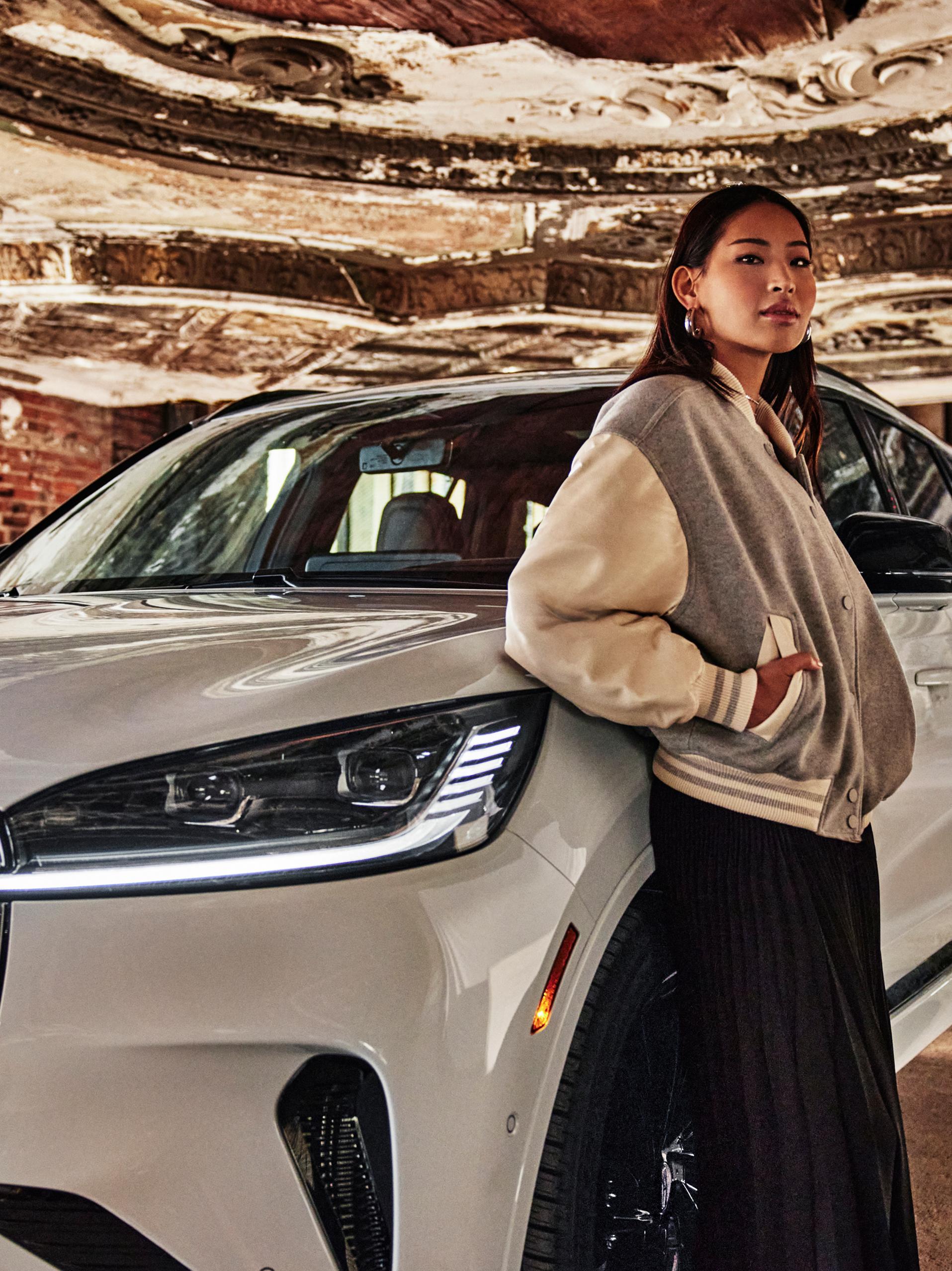 Une femme appuyée sur un Lincoln Aviator 2025 blanc.