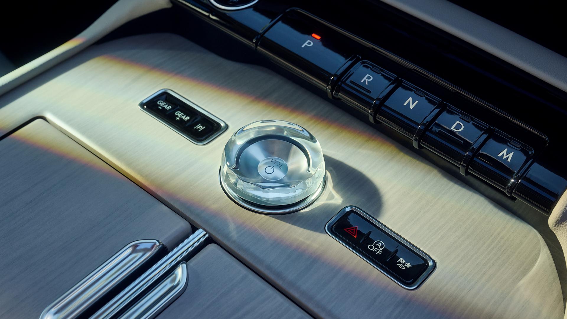 Gros plan sur le bouton en cristal et le levier de vitesses en forme de touche de piano sur la console centrale d'un Lincoln Navigator® 2026.