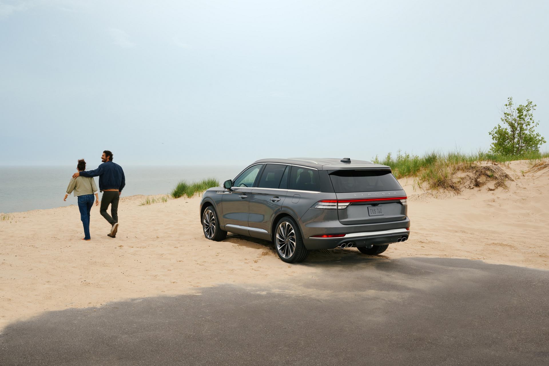 Un Lincoln Aviator® 2027 stationné près de dunes de sable au bord d’un lac