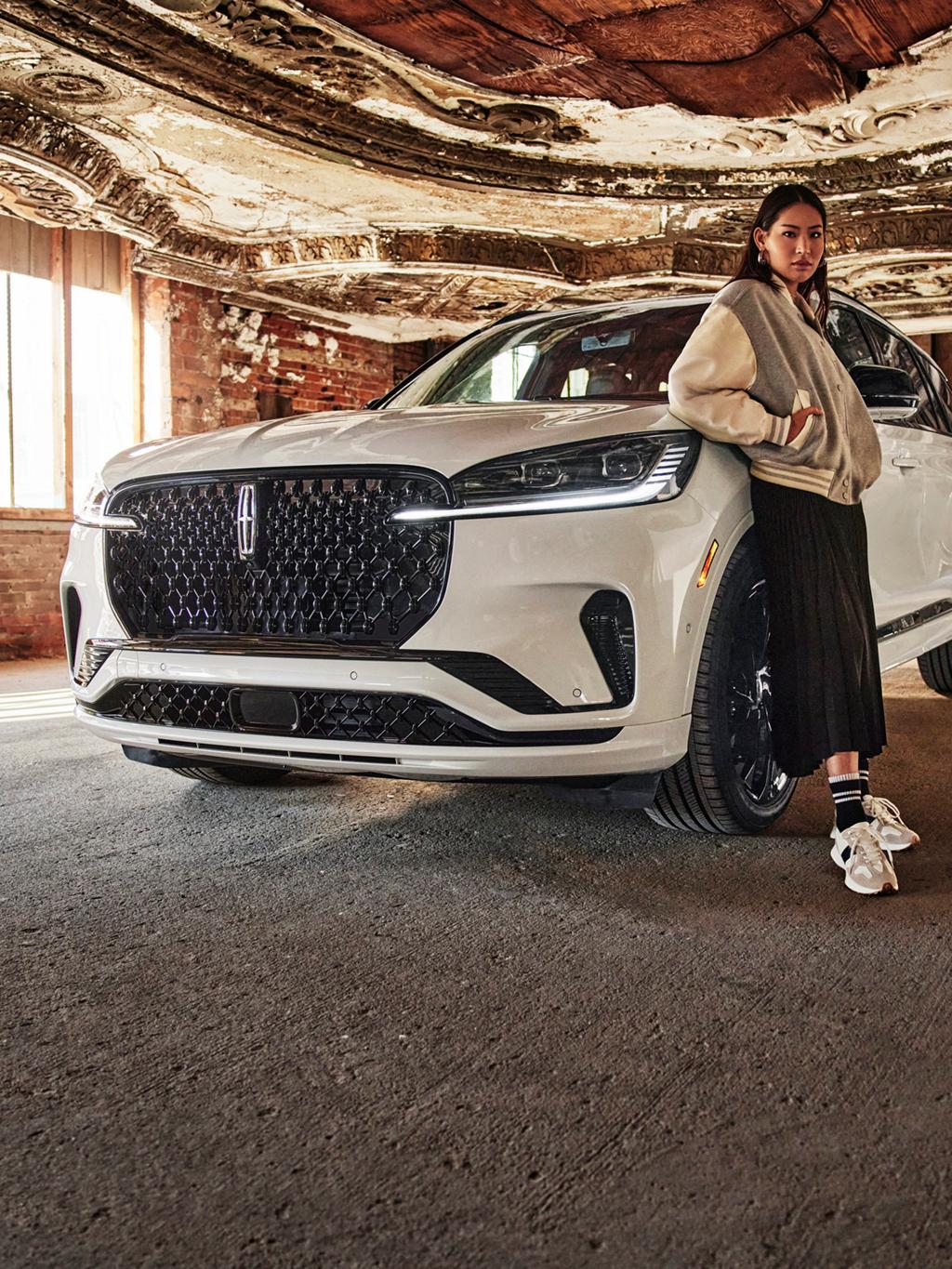 Une femme debout devant un véhicule Lincoln.