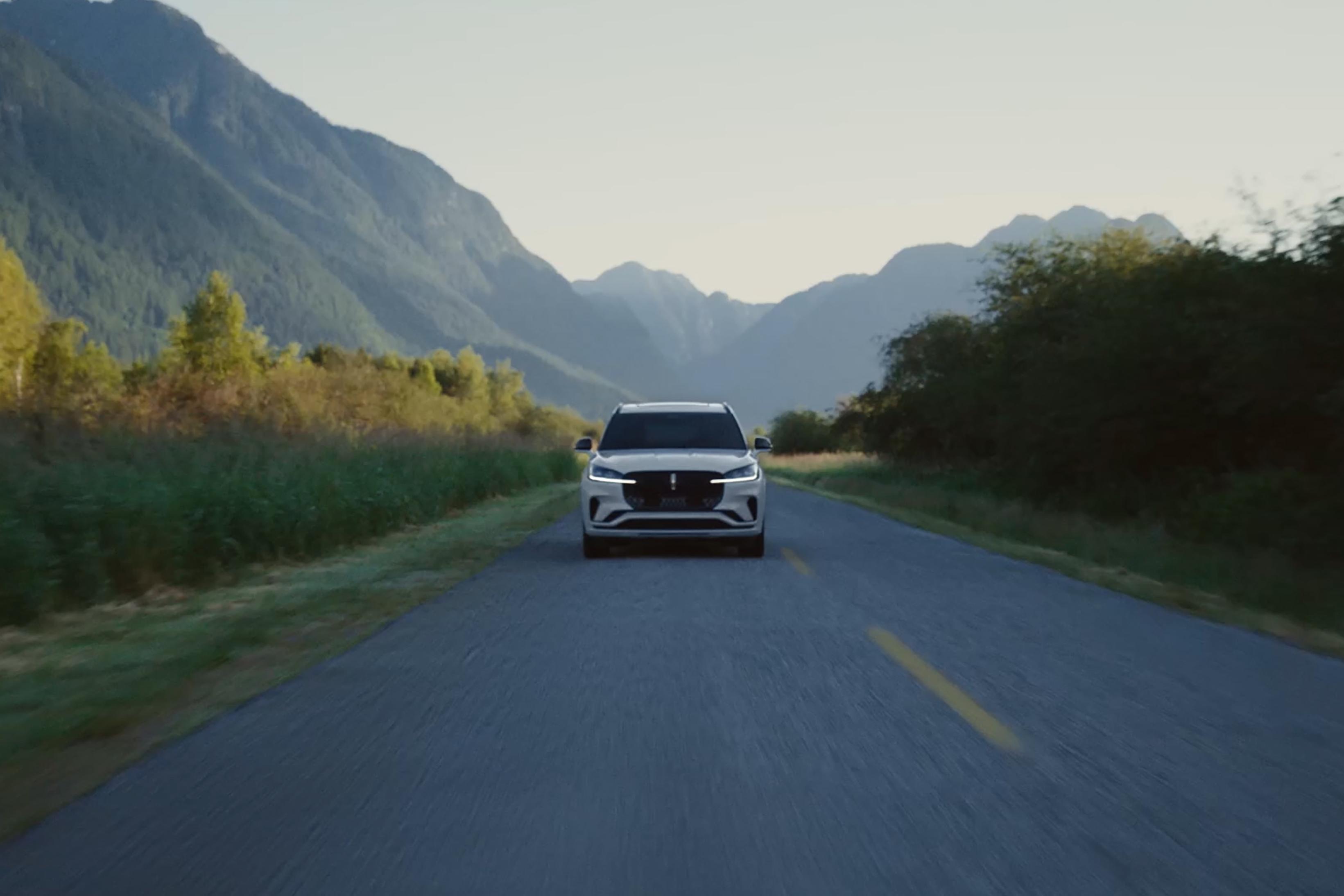 Un Lincoln Aviator® 2027 circulant sur une autoroute, avec des montagnes en arrière-plan