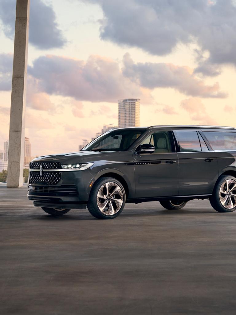 Un VUS Lincoln Navigator® 2026 à empattement long est stationné sur une route bordée d’arbres