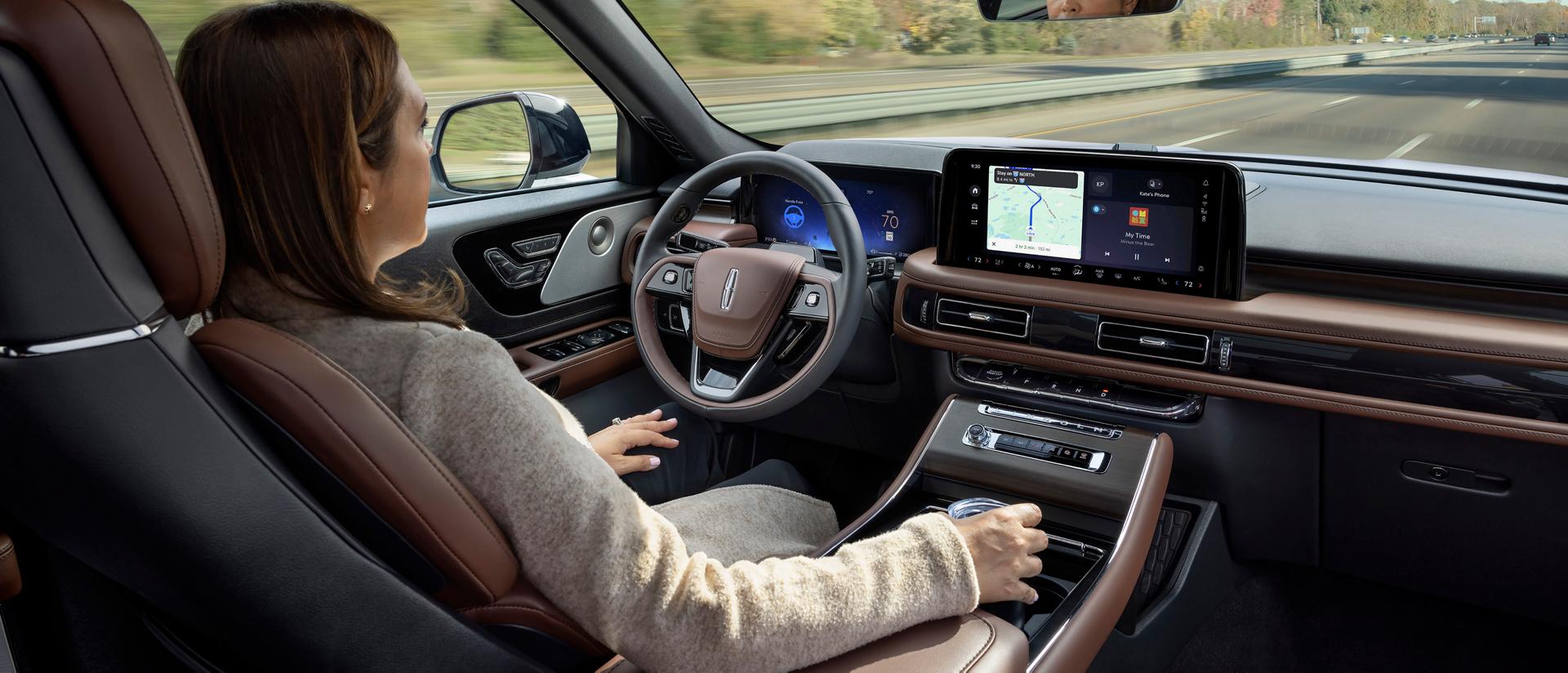 Une femme conduit un Lincoln Aviator® 2026 en mode mains libres, les yeux rivés sur la route, grâce au système Lincoln BlueCruise