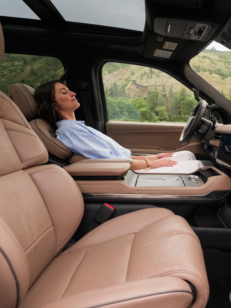 Une femme s’incline dans un Lincoln Navigator® Black Label 2026 tandis que les fonctions Rejuvenate joue à l’écran.