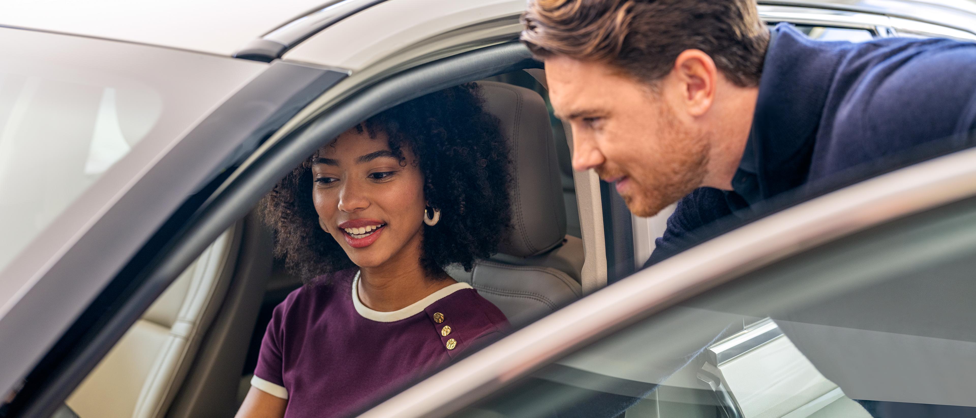 Un représentant des ventes Lincoln montrant à un client une caractéristique à l’intérieur du véhicule Lincoln