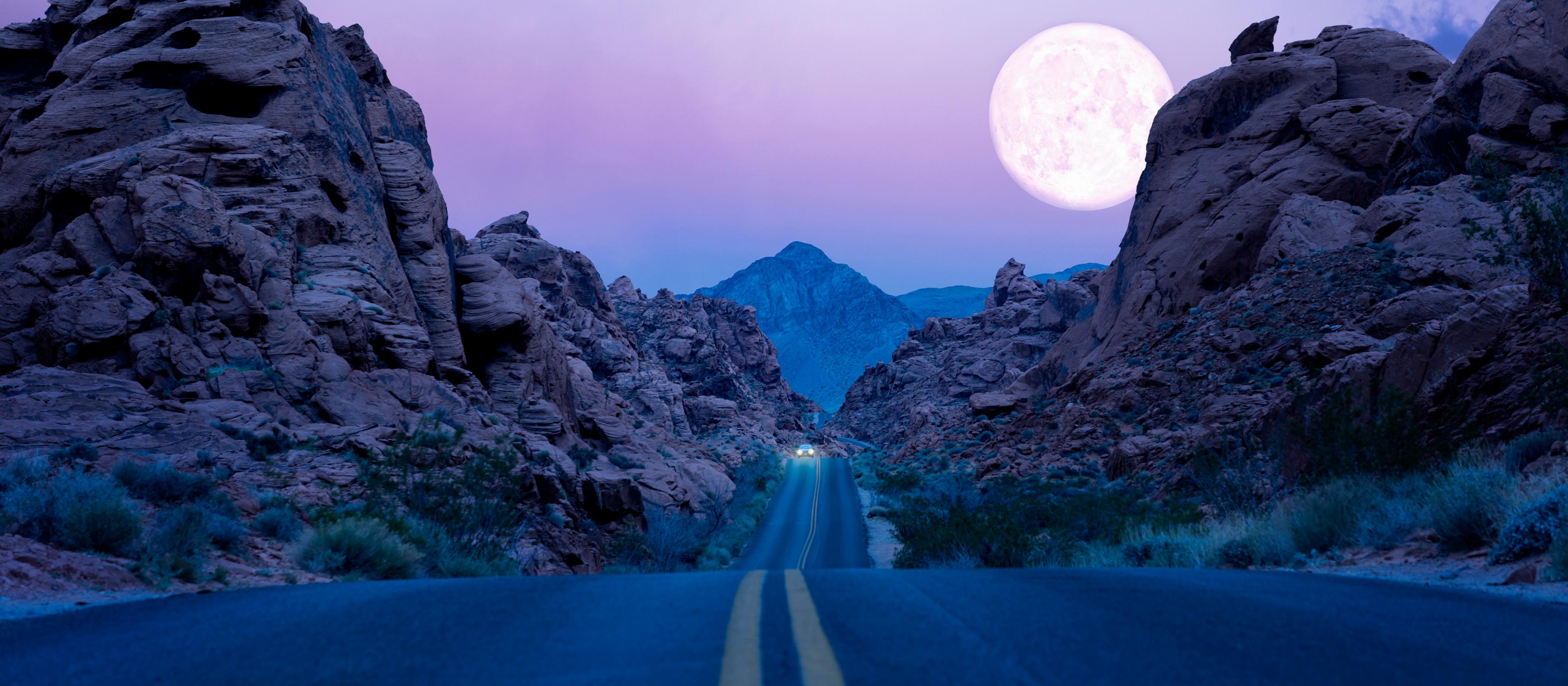 La lune se lève au-dessus d’une autoroute du Sud-Ouest désertique la nuit.