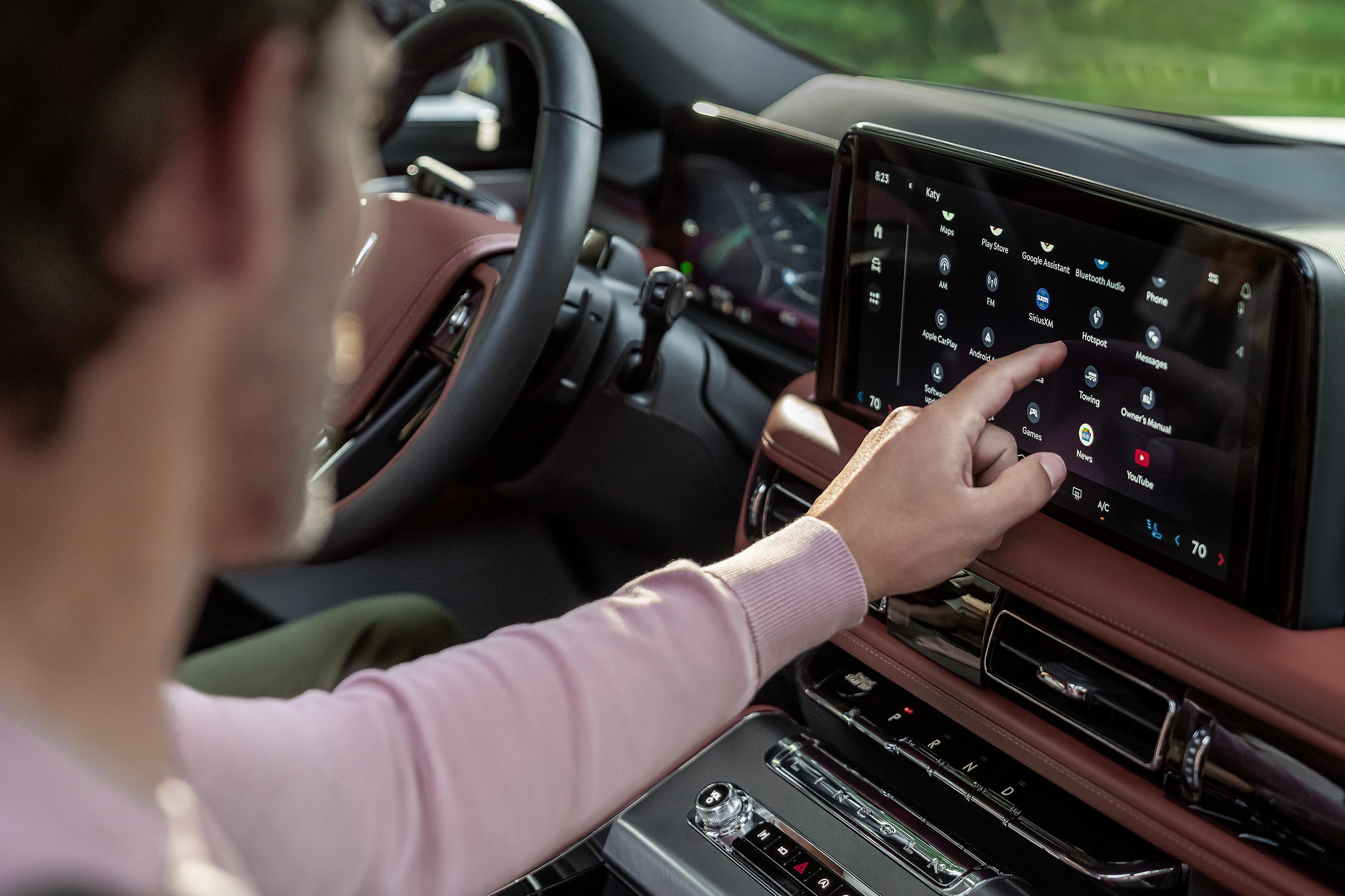 Le conducteur d’un Lincoln Aviator 2026 qui interagit avec un écran tactile.