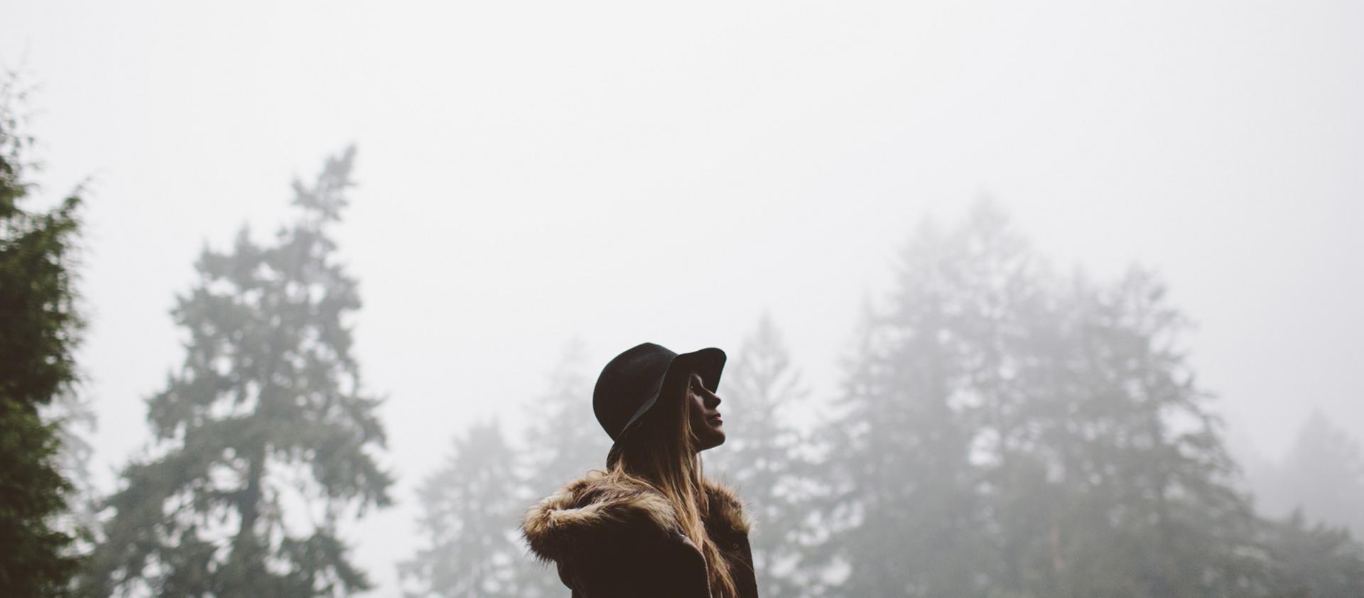 Une femme marche dans la forêt à la fin d'un orage