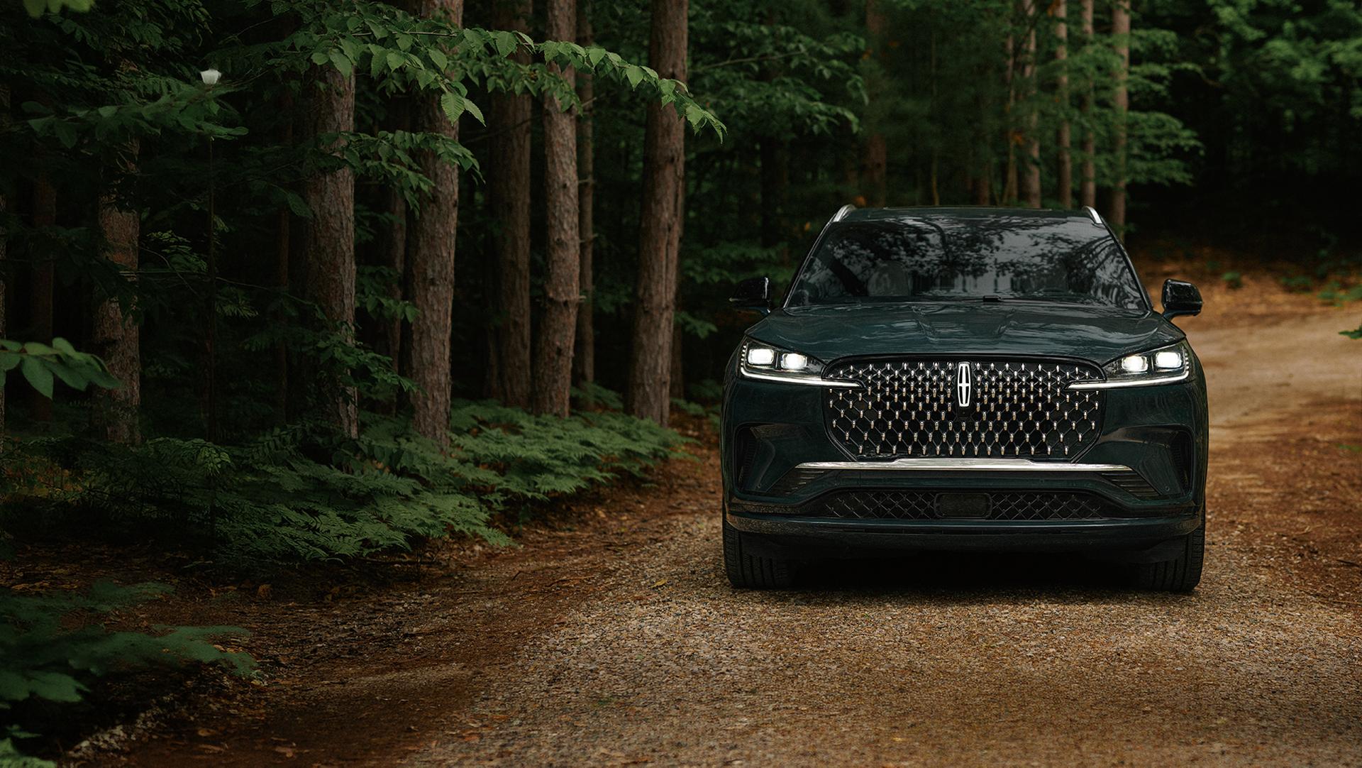 Un Lincoln Aviator® 2027 circulant sur une route forestière isolée